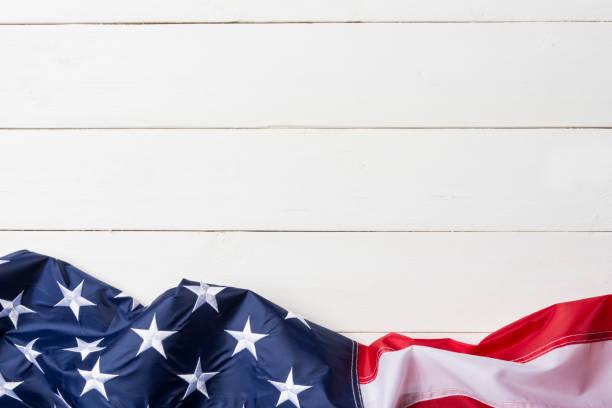 American flag lying on old white wooden background