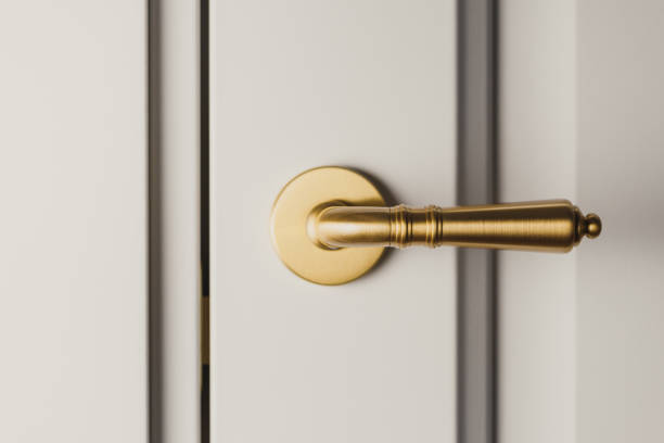 istock Brushed gold modern design in vintage style door handle on a white door. 1210513773