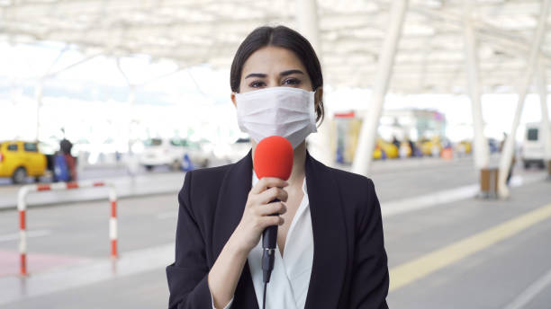 TV reporter wearing a mask