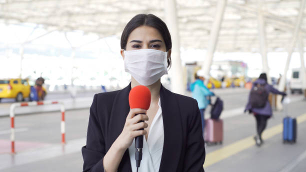 istock TV reporter wearing a mask 1210513799