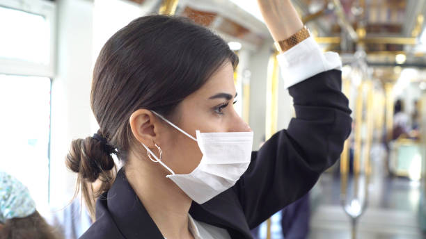 Businesswoman wearing a mask while traveling stock photo