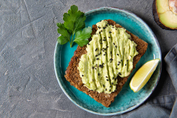 istock Avocado toast on whole grain bread, mashed avocado with sesame seeds and lime, healthy eating concept, top view 1210515126