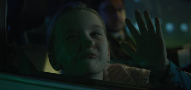 Medium shot of girl pushing face against car window at night