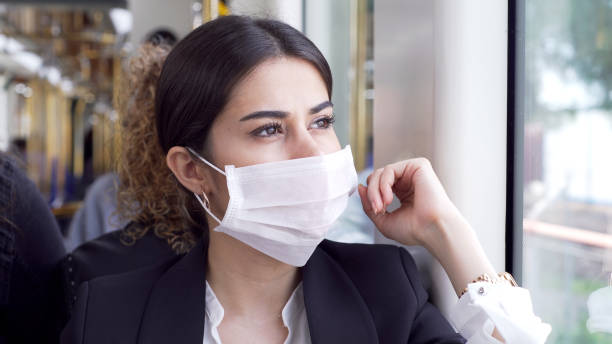 Businesswoman wearing a mask while traveling Businesswoman wearing a mask while traveling. commuter train photos stock pictures, royalty-free photos & images