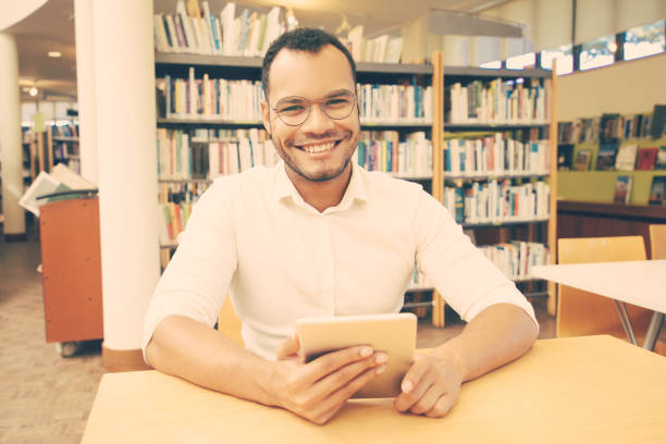 istock Happy male customer using public Wi-Fi hotspot in library 1210517453
