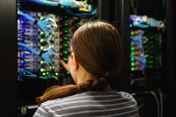 woman networking engineer near working server rack - network server computer network rack computer part imagens e fotografias de stock