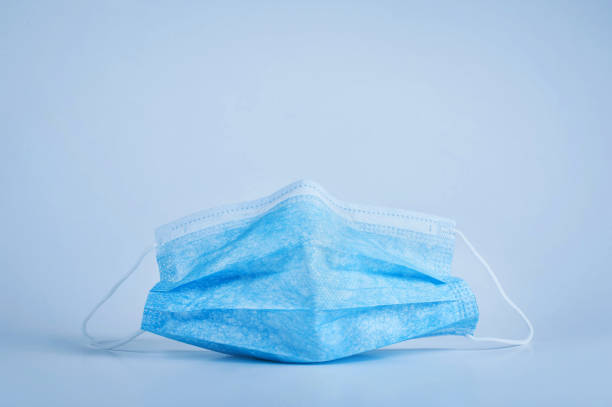istock Blue protective medical mask on a blue background close-up 1210519952