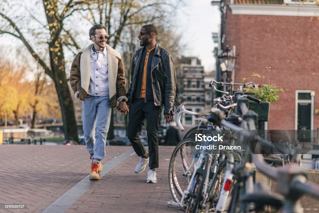 Millennial gay couple on city break Millennial gay couple on city break, exploring magical streets and canals of Amsterdam, The Netherlands Gay Couple Stock Photo