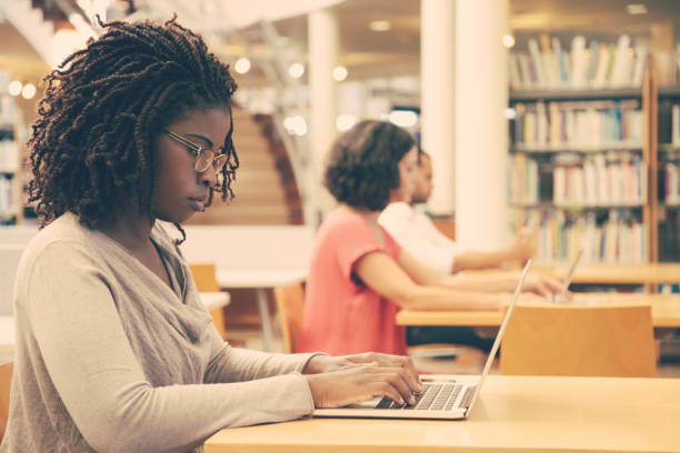 istock Focused female customer using public wi-fi hotspot in library 1210520934
