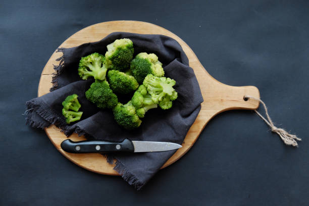 istock healthy breakfast: Fresh raw broccoli on a wooden board on a dark background. 1210521928
