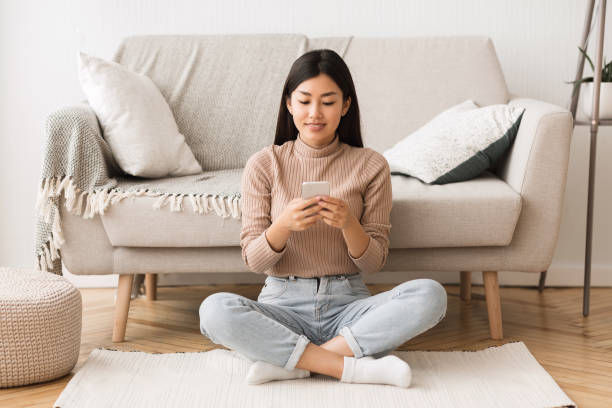 istock Free time. Asian girl browsing on smartphone 1210523559