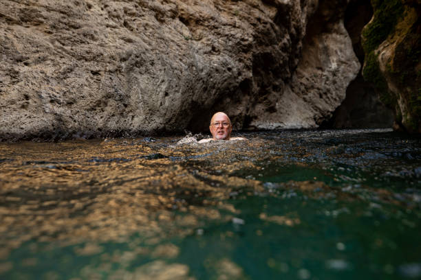 istock Senior Man Swimming in a Cave 1210525205