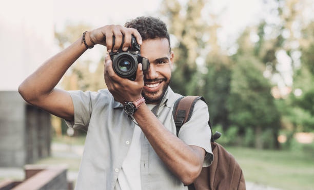 photographe de jeune homme prenant des photos dans une ville - prendre une photo photos et images de collection