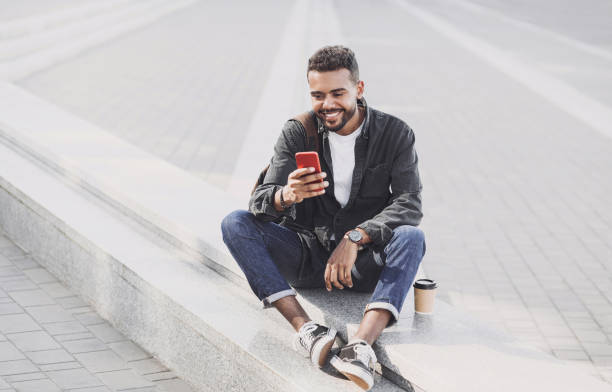 istock Handsome young man using smart phone on a city street 1210526480