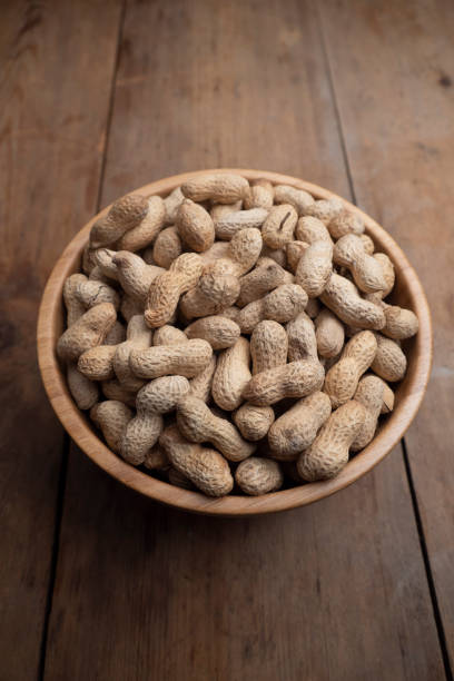 istock Wooden bowl of roasted peanuts in shells 1210528591