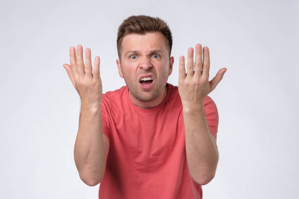 istock man with grumpy grimace on his face,with mouth opened in shout, ready to argue 1210530918