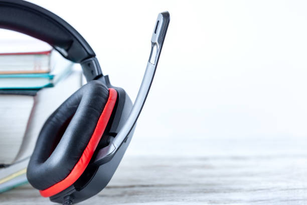 modern headphones and books on table on white background. concept of audiobook. - hardcover book audio imagens e fotografias de stock