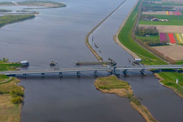 Ramspolbridge and storm barrier wit the delta of the river IJssel in the background Inflatable rubber dam at Ramspol near Kampen in The Netherlands. Inflatable rubber dams are cylindrical rubber fabrics placed across channels, streams and weir or dam crests to raise the upstream water level when inflated.