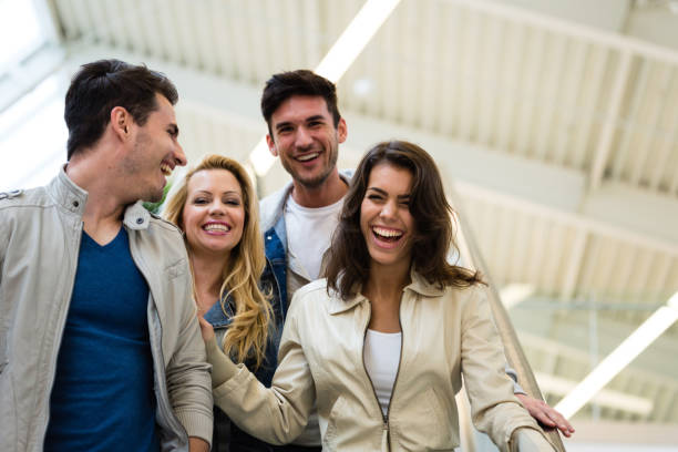 istock Friends having fun and laughing while riding the escalator at the shopping mall 1210533241