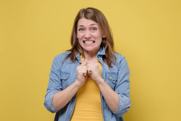 Awkward caucasian woman feeling embarrassed, confused nervous before exam Awkward caucasian woman feeling embarrassed, confused nervous before exam isolated on yellow studio background. Omg I made a terrible mistake. regret stock pictures, royalty-free photos & images