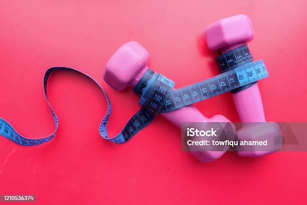 Top View Of Dumbbell And Measurement Tape On Pink Background Stock Photo - Download Image Now