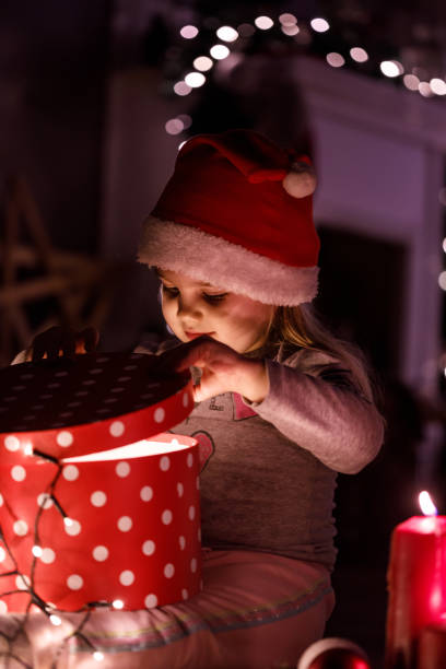 istock Curious girl exploring a Christmas gift box 1210537140