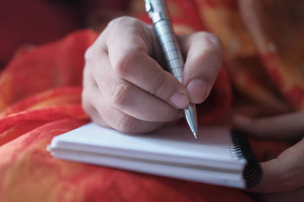 istock Close up of women hand writing on notepad 1210537808