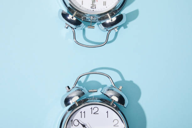 istock top view of classic alarm clocks on blue background 1210538008