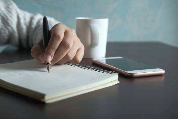 istock Close up of women hand writing on notepad 1210538537