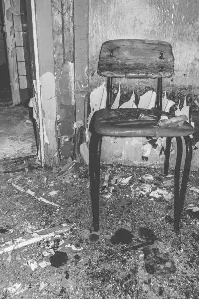 an old wooden chair in a dilapidated house in black and white