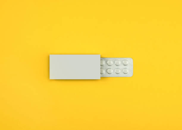 Pills in a box on a background Pills in a box on a yellow background tablets blister stock pictures, royalty-free photos & images
