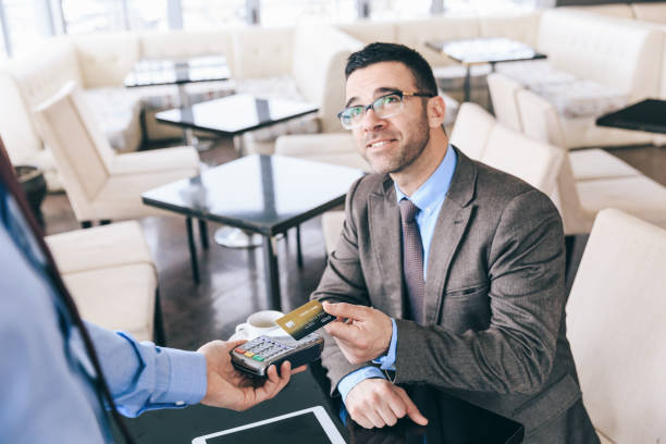 istock Businessman using credit card for contactless payment in cafe 1210541612