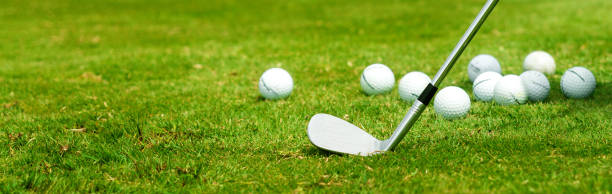 Golf iron and balls in the grass banner format stock photo