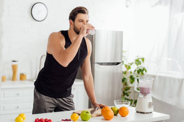istock bearded man drinking fresh smoothie near blender and fruits 1210543214