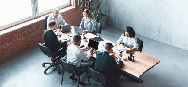 istock Multiethnic Business Team Working Together Sitting In Modern Office, Panorama 1210544635