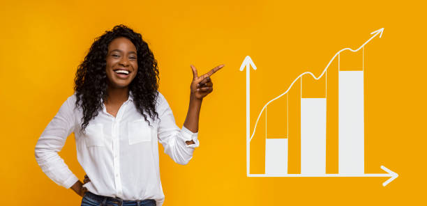 glückliche afroamerikanische frau zeigt beiseite auf business-graph - wettbewerb konzepte grafiken stock-fotos und bilder