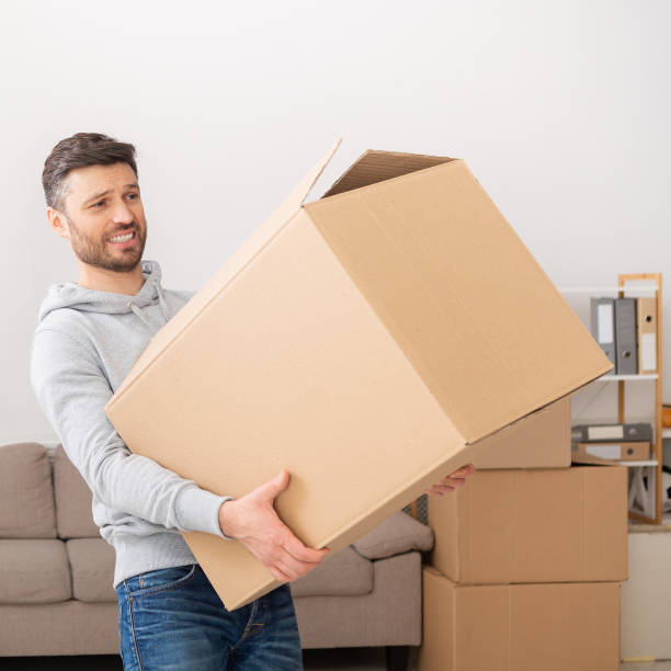 istock Man transferring heavy box while moving in new apartment 1210544936