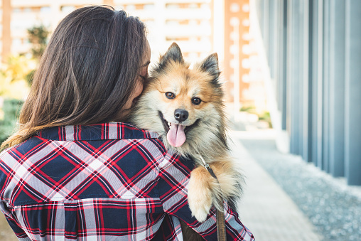 woman kissing dog with copy space for text