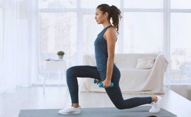 slim hispanic girl doing lunges with dumbbells at home, empty space - aerobics imagens e fotografias de stock