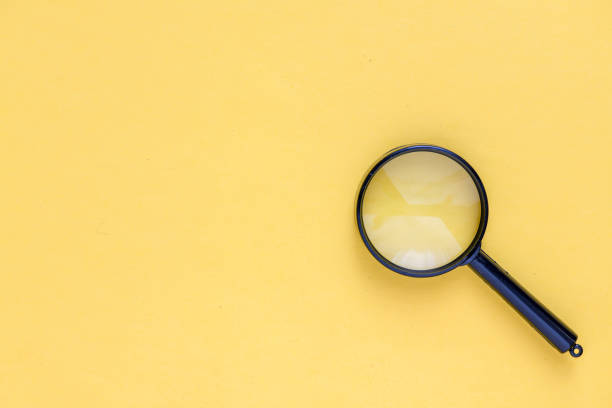 istock close up magnifier glass on yellow background 1210548491