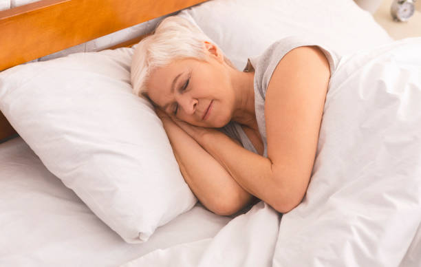 istock Senior lady sleeping in bed in morning, panorama 1210548531