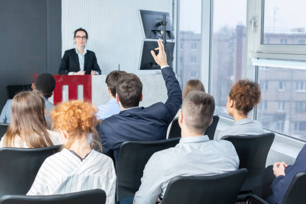 istock Businessman raising hand at seminar, having question to speaker 1210548562