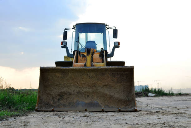 Front-end loader working on construction site during the renovation of the road. Laying or replacement of underground storm sewer pipes. Installation of water main, sanitary sewer, storm drain systems cargador frontal que trabaja en el sitio de construcción durante la renovación de la carretera. colocación o sustitución de tuberías subterráneas de alcantarillado pluvial. instalación de agua principal, alcantarillado sanitario, sistemas de drenaje