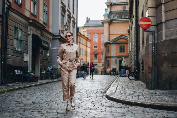 Modern woman exploring rainy Stockholm Modern woman on rainy day enjoying beautiful day in Stockholm jumpsuit stock pictures, royalty-free photos & images