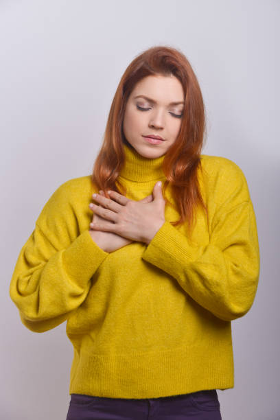 istock Calm young woman with hands on chest 1210550089