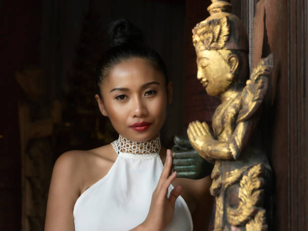 istock Asian woman standing behind gold budha 1210551015