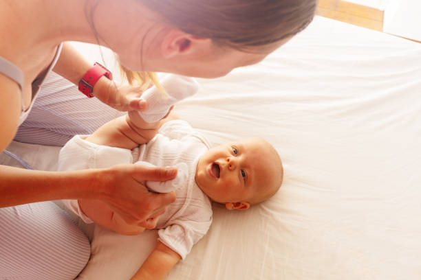 istock Young mother play with laughing infant on the bed 1210551171