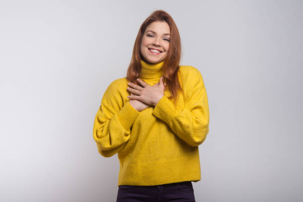 Cheerful young woman with hands on chest