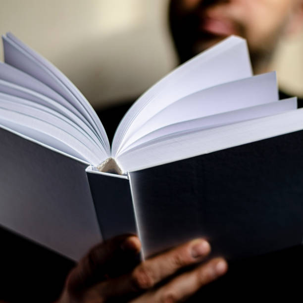 istock An open white book is ready to be read in the hands of a man. 1210551363