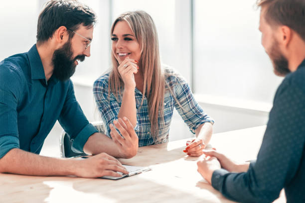 istock group of successful young people sitting at the negotiating table. 1210552825